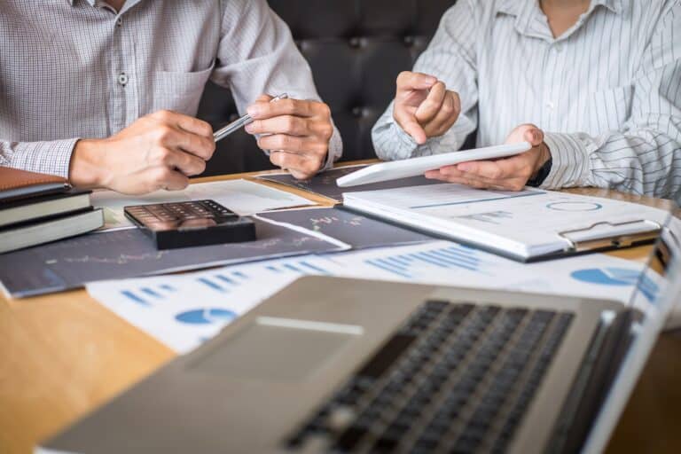 Hommes planifiant les ressources, les besoins financiers et les budgets du cahier des charges